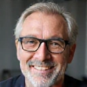 Ritratto di Paolo Ricci, un uomo di mezza età con occhiali, che sorride calorosamente, trasmettendo un senso di calma e soddisfazione.